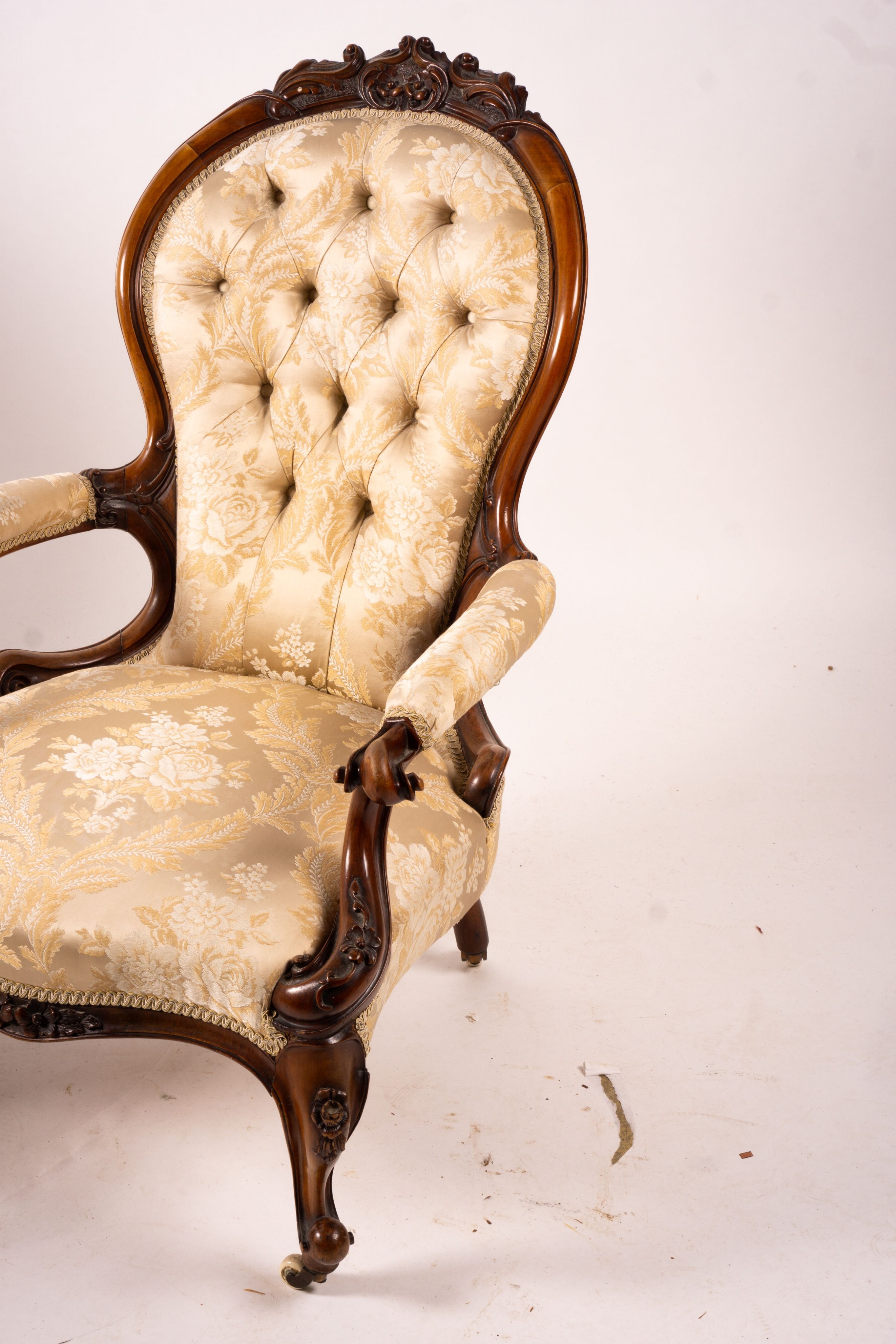 A late Victorian carved walnut three piece salon suite, comprising chaise longue, open armchair and nursing chair